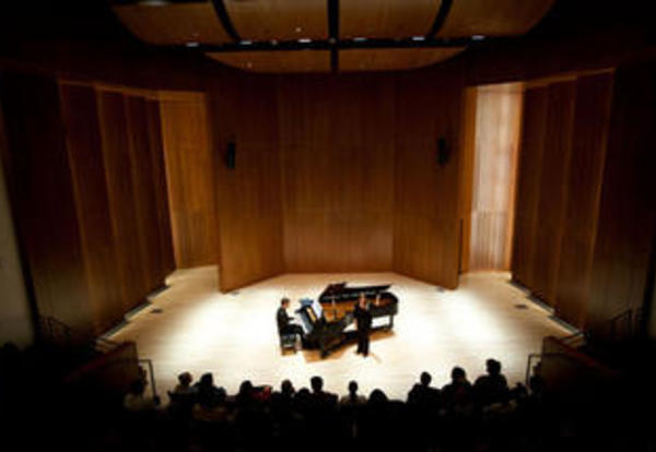 A pianist performing before an audience in Carol Hall