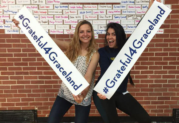Two female students show off the #Grateful4Graceland signs