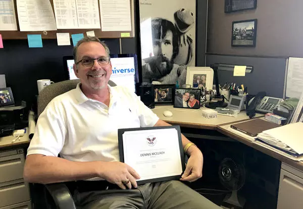 Professor of Education Dennis McElroy shows off his President's Volunteer Service Award certificate.