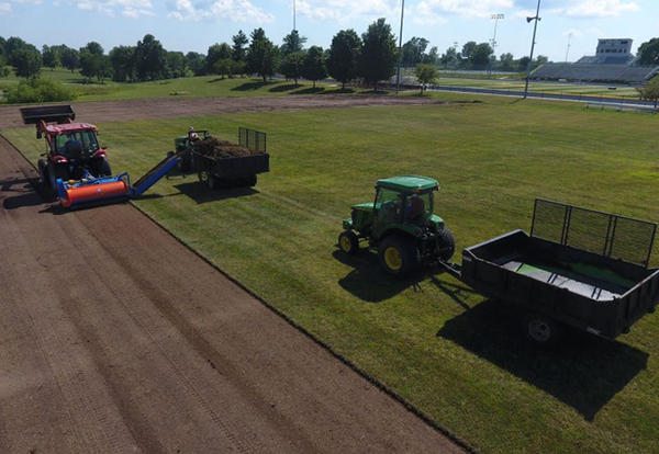 Tractors roll new sod over Rasmussen Soccer Field on the Lamoni campus