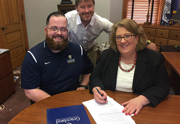 Professor Geiselman, Professor White and President Draves sign an agreement with Logan University