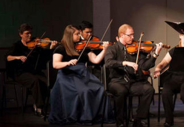 Members of the Graceland Orchestra performing with their instruments