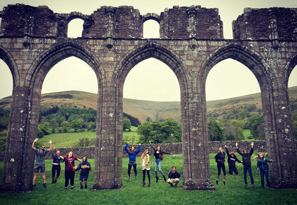 A group of students in England at arched stone remnants during summer session