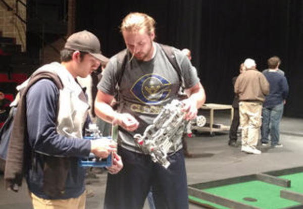 Two male Graceland students inspecting their robot at the Robotics Competition