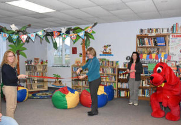 Graceland alum Leslie Niebauer `15 in a school library with two other teachers preparing for students