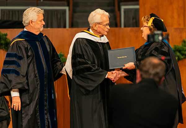Pat Draves and Harry Ashenhurst present the Honorable Leonard L. Boswell with an honorary doctorate
