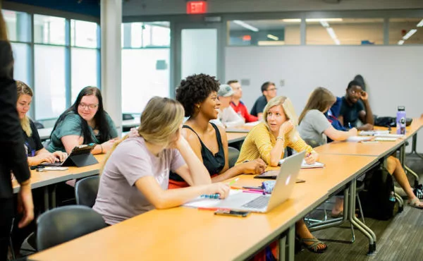 Students sit together in class and talk