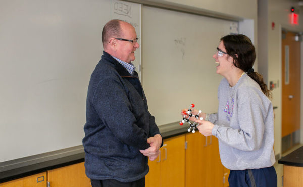 Student enjoys a laugh with professor in class