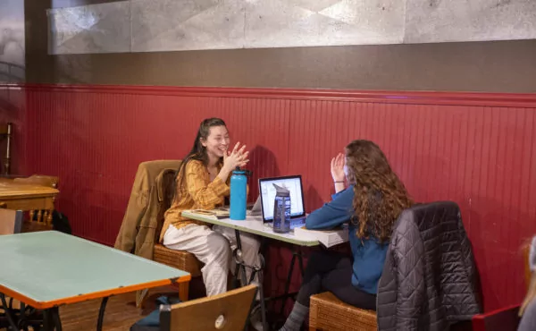 Students chatting at the coffee shop working on homework