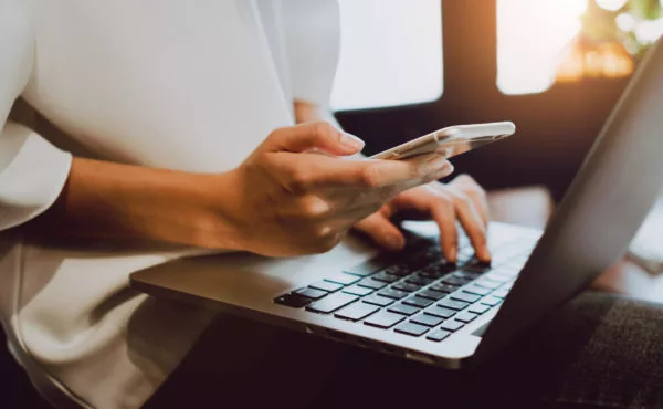 Soft focus of woman hand working with phone on desk in coffee shop. Vintage tone