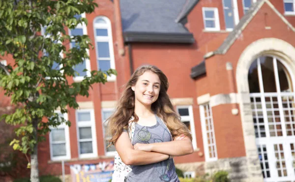 smiling student standing outside Higdon Ad building