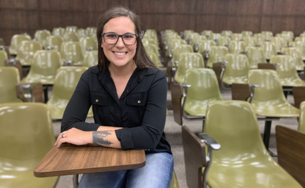 smiling student sitting at desk in classroom