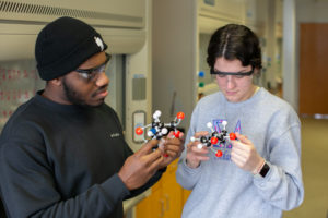 students examine molecular model during science class