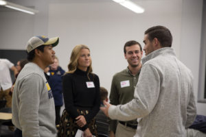 alumni talks with students at networking event