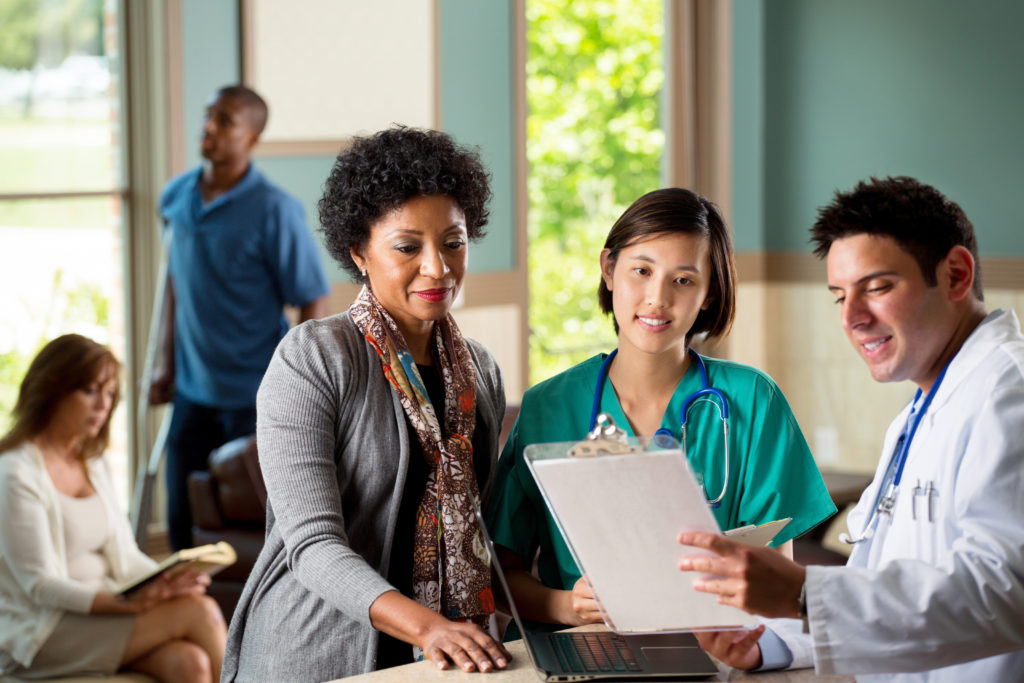 stock photo of health care providers looking at patient chart in hospital setting