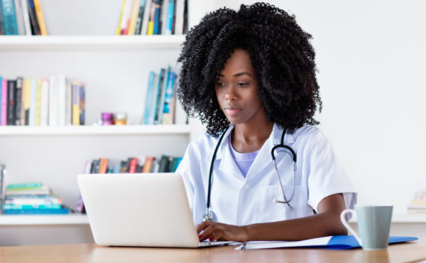 Researching african american medical female student at computer
