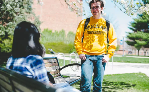 smiling students talking outside on campus