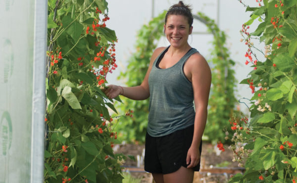 smiling female student working in hoop house