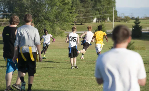 male students playing intramural flag football on practice soccer field