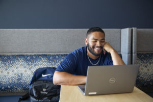 smiling student working on laptop in student union