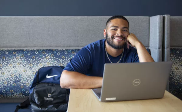 smiling student working on laptop in student union