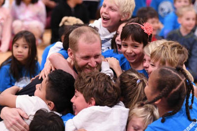 Bessonette is shown surrounded by excited students.