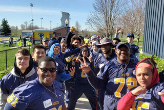 A group of volunteers from Graceland Football line up ready to welcome Special Olympics athletes.