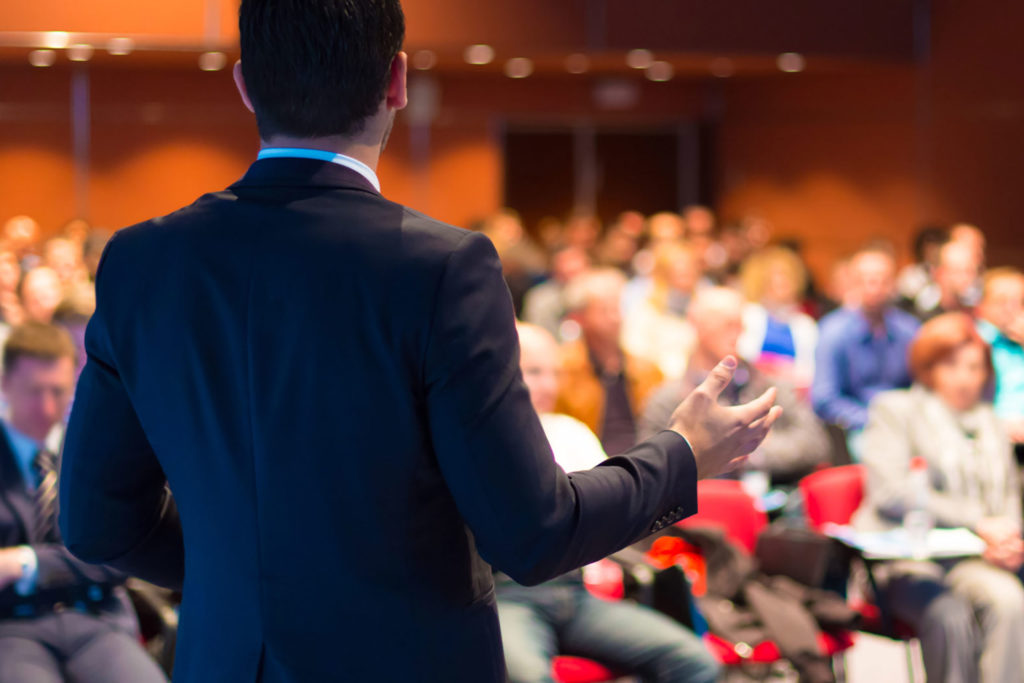 Man speaking in front of conference