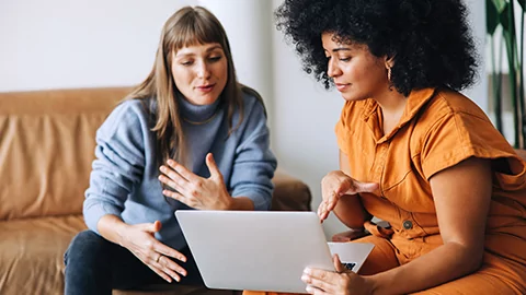 Two women working on a laptop.